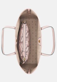 Pink tote bag with leather material features an inner zippered pouch, geometric pattern, and a logo printed lining. Soft, structured shape.