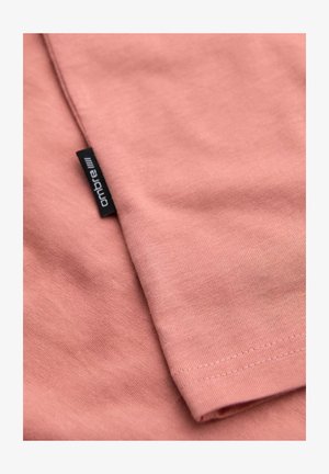 Světle růžové tričko s krátkým rukávem vyrobené z měkké tkaniny. Obsahuje vyšitý lem a malou černou etiketu s textem "ombre".