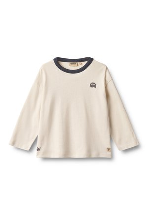 Chemise enfant à manches longues de couleur crème avec un col rond foncé et de petits motifs pixellisés de space invaders sur la poitrine et le bas du côté.