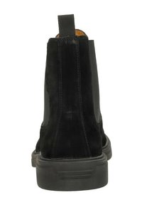 Bottines en suède noir avec des panneaux latéraux élastiques, une languette à l'arrière, et une semelle en caoutchouc texturée pour une meilleure adhérence.