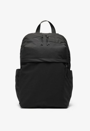 Black fabric backpack with dual zippers, padded straps, and front pocket. Features side mesh pockets and a sleek, minimalist design.