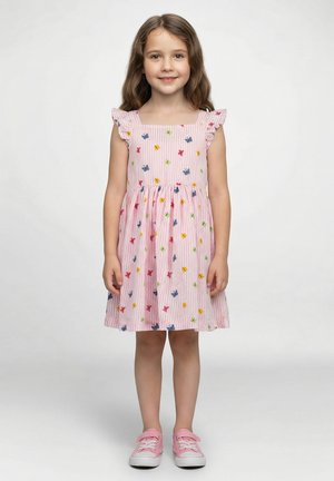 Abito a righe rosa con spalline arricciate, decorato con motivi floreali multicolori. Indossato con sneakers rosa per un look casual.