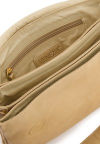 Hellbeige Lederhandtasche mit glatter Textur, ausgestattet mit einer Reißverschlusstasche und einem Logo-Anhänger im Inneren. Zwei Hauptfächer, einfaches Design.