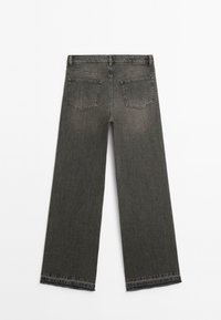 Jeans a gamba larga grigio scuro con vita alta, caratterizzati da cuciture visibili, due tasche posteriori e un dettagli di orlo sfrangiato.