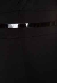 Tissu noir à texture lisse avec une ceinture noire brillante à la taille, mettant en valeur une coupe ajustée et des lignes épurées.