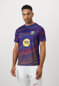 Barcelona fotbollströja i blått med flerfärgade horisontella ränder. Har Nike-logotyp, Spotify-skyltning och lagets emblem på bröstet.