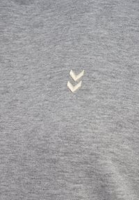 Pullover grigio in maglia con un logo a zig zag ricamato grigio chiaro sul petto. Il tessuto sembra morbido con una consistenza sottile.