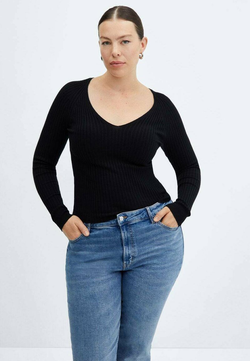 Zwarte geribbelde longsleeve top met een V-hals, gecombineerd met lichtblauwe hoge taille jeans. De stof lijkt zacht met een aansluitende silhouet.