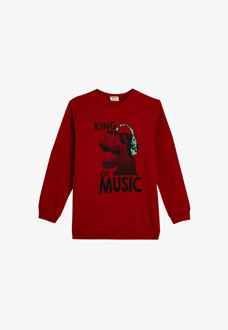 Sudadera roja de manga larga con un gráfico negro de un dinosaurio que lleva auriculares. El texto dice "REY DE LA MÚSICA" en una fuente en negrita.