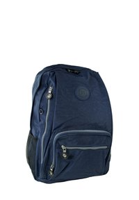 Sac à dos bleu marine avec une texture lisse, plusieurs compartiments zippés et une poche latérale en maille. Présente un logo rond sur le devant.
