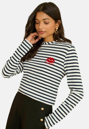 Langärmliges, marineblau-weiß gestreiftes Oberteil mit Rundhalsausschnitt, mit einem roten, gestickten Lippen-Design und einem kleinen Logodetail.