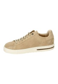 Sneaker beige in suede con punta tonda, chiusura con lacci e suola in gomma bianca texturizzata. Presenta un piccolo accento decorativo sulla suola.
