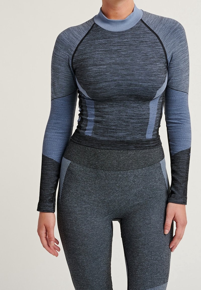 Camiseta deportiva de manga larga en tonos gris oscuro y azul, con un cuello acanalado, paneles texturizados y un diseño ajustado.