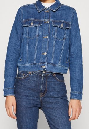 Chaqueta de mezclilla en azul oscuro con cuello, bolsillos en el pecho, botones plateados y un corte corto. Tejido texturizado con costuras visibles.