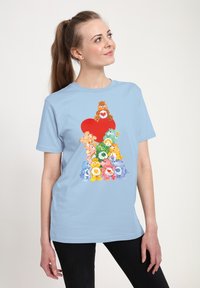 T-shirt blu chiaro con grafiche di orsi colorati impilati a piramide con un cuore rosso in cima; maniche corte, design a collo rotondo.