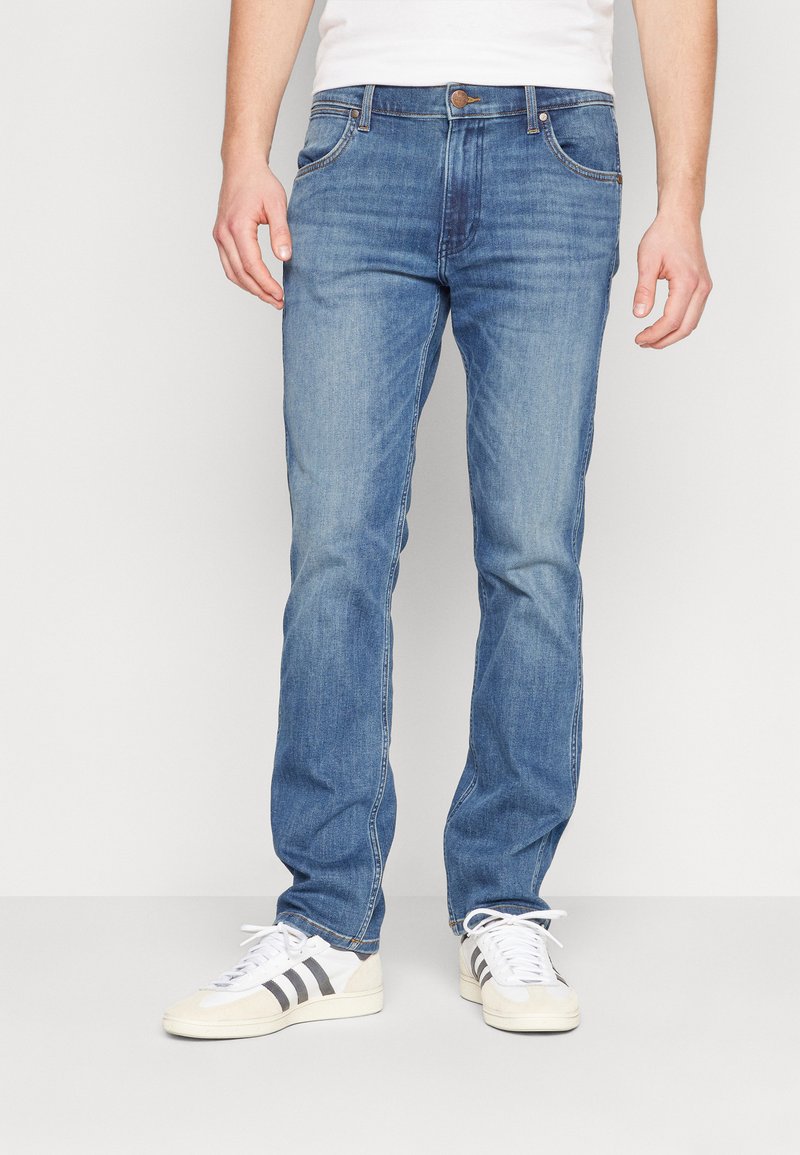 Jeans de denim albastru deschis, cu croială dreaptă, design cu cinci buzunare, cusături în contrast și o etichetă din piele maro pe talie.