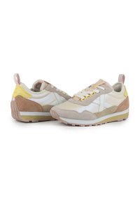 Beige and white athletic sneakers with suede accents, a textured sole, yellow and pink details, and a lace-up design.