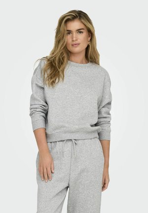 Sweatshirt gris à col rond, avec des poignets et une taille côtelés. Tissu doux, coupe décontractée, associé à un pantalon à cordon assorti.