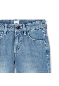 Light blue denim jeans with a standard waist, five pockets, and a black button closure. Features subtle fading and contrast stitching.