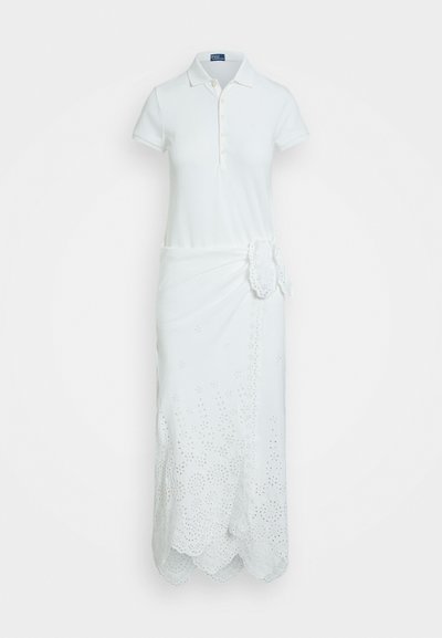 Bijela pamučna haljina s polo kragnom, kratkim rukavima i višeslojnim suknjom s cvjetnim izrezanim uzorcima i valovitom ivicom.