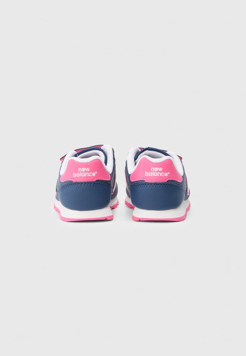 Baskets de sport bleues et roses avec une tige en maille, doublure blanche et semelle texturée. Équipées d'une bande Velcro et du logo "new balance" à l'arrière.