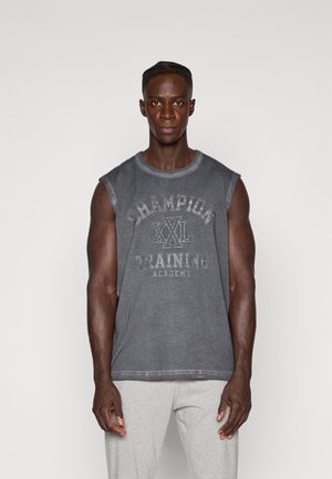 Gray sleeveless t-shirt featuring a prominent faded print that reads "Champion XL Training Academy," paired with light gray sweatpants.