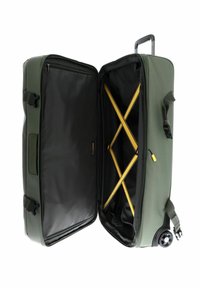 Grüner Koffer mit robustem Äußeren, schwarzem Innenraum, gelben Kreuzgurten und einer seitlichen Reißverschlusstasche, die teilweise geöffnet ist.