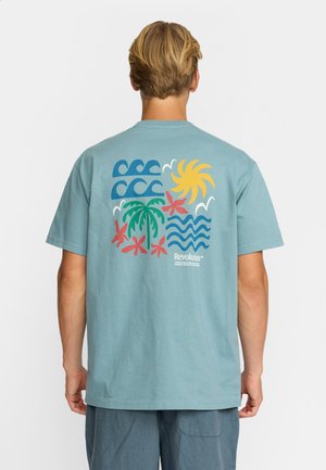 Helles blaues Baumwoll-T-Shirt mit kurzen Ärmeln, das auf der Rückseite eine farbenfrohe tropische Grafik mit Wellen, Sonne, Palmen und Blumen zeigt.