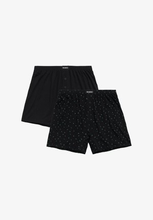 Czarne bokserki w kropki oraz druga para z zielonym wzorem liści na czarnym tle; obie z guzikiem z przodu i elastycznym pasem.