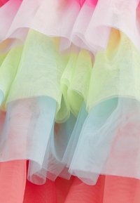 Tissu en tulle multicolore avec des volants superposés ; présente des teintes de rose, lavande, vert et corail. Texture douce et transparente avec une apparence légère.