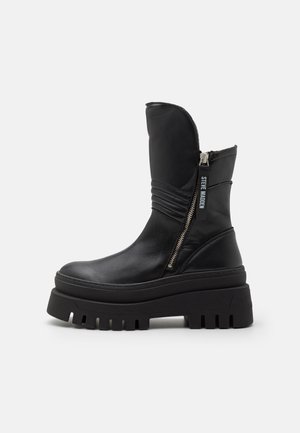 Svarta ankle boots med en tjock plattform, tillverkade av läder. Utrustade med en sidodragkedja, texturerade detaljer och en rund tådesign.
