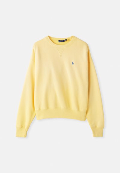 Felpa gialla in cotone, con colletto a girocollo, polsini a coste e un piccolo logo blu sul lato sinistro del petto, texture morbida.