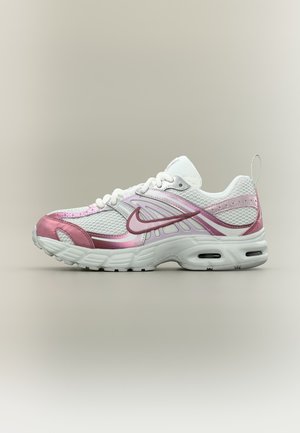 Chaussure de running Nike en mesh blanc et rose avec lacets sur le dessus et amorti à air visible dans la semelle, vue de l’extérieur.