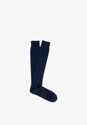 Calzini al ginocchio blu navy con piccoli pois rossi e polsini a coste, mostrati distesi su uno sfondo bianco.