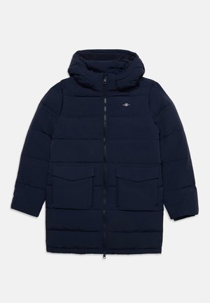 Cappotto invernale imbottito blu navy con cappuccio, cerniera frontale, due grandi tasche con patta e un piccolo logo ricamato sul petto.