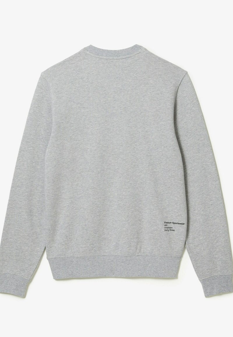 Sweatshirt en coton gris avec un col rond, des manches longues, des poignets et un ourlet côtelés. Petit graphisme en texte noir sur le bas à gauche.