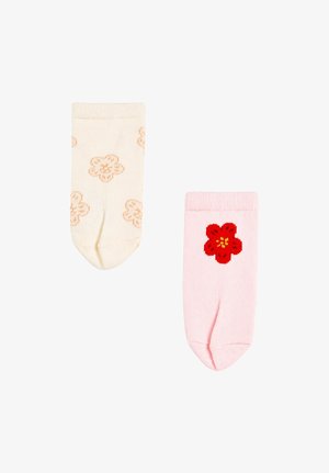 Deux chaussettes pour bébé, une crème avec des fleurs orange clair, une rose avec une seule fleur rouge devant.