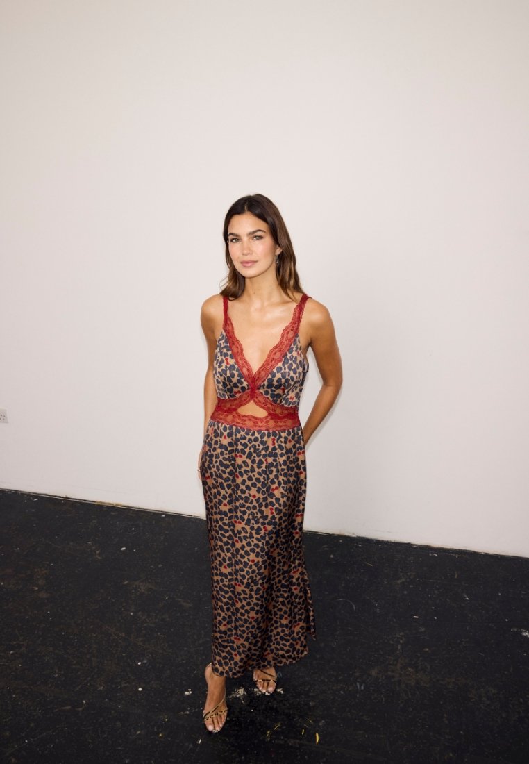 Abito con stampa leopardata, rifinito con pizzo rosso, scollo a V e dettaglio con apertura in vita. Silhouette fluida e tessuto morbido.