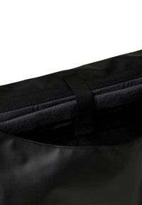 Fekete szövet táska struktúrált felülettel. Belső bélése sötét bolyhos anyag és egy hálós zseb. Fekete szövetpánttal zárható.