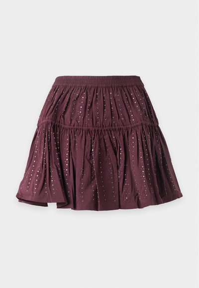 Jupe courte bordeaux à volants avec taille élastique et petits sequins brillants dispersés sur le tissu.