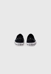 Mustad musta kangaga madala äärega kingad, metallist silmadega, valged kummist tallad ja kontrastne õmblus. Omab "Converse All Star" logo kontsadel.