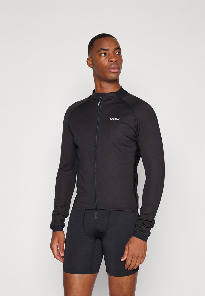 Schwarzes Langarm-Radtrikot mit Reißverschluss und figurbetontem Design. Mit einem Logo auf der Brust und leichten, dehnbaren Stoff.