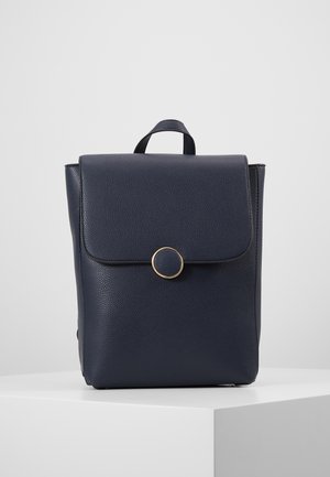 Sac à dos en cuir marine avec une finition texturée, doté d'un rabat avant, de quincailleries rondes en or et d'une poignée supérieure pour le porter.