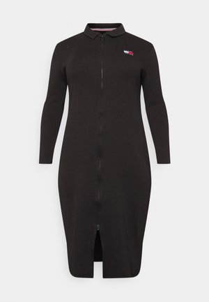 Czarna sukienka midi z długim rękawem, z suwakiem z przodu, kołnierzykiem, małym logo w kolorach czerwonym, białym i niebieskim na piersi oraz rozcięciem z przodu u dołu.