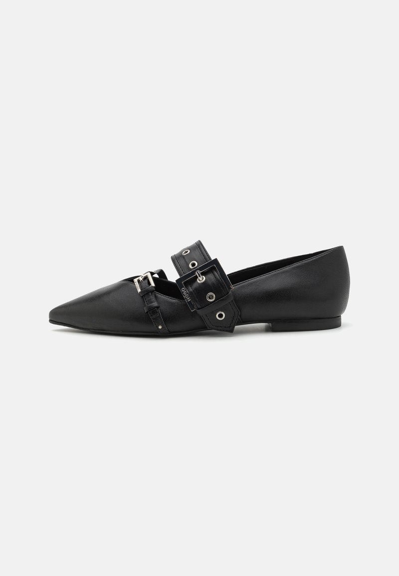 Chaussure plate noire à bouts pointus avec deux brides à boucle réglables et une finition lisse, présentée de profil sur fond blanc.