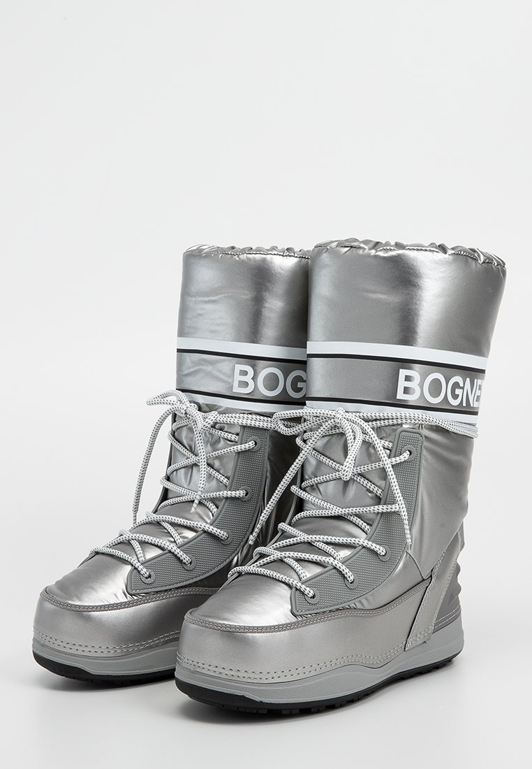 Silberne Schneestiefel mit glänzender Oberfläche, robuster Gummisohle, Schnürdesign und markierter Mittelpartie mit einem weißen Logo-Band.