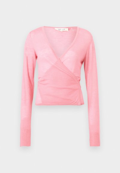 Haut cache-cœur à manches longues rose pâle avec col en V et taille cintrée sur un fond clair uni.