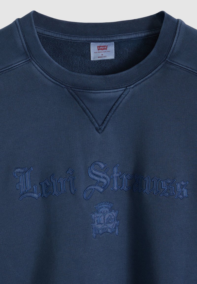 Felpa navy a vestibilità boxy, realizzata in tessuto morbido, con ricamo testurizzato "Levi Strauss" e logo stemma sul davanti.