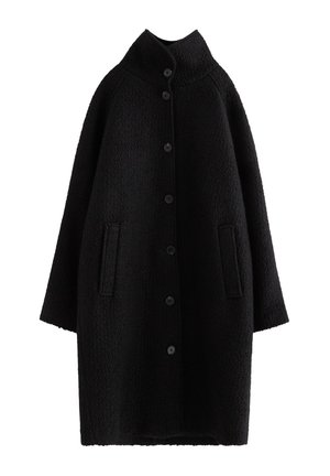Sort oversized frakke med en tekstureret overflade, høj krave, 6 frontknapper og to sidelommer. Ærmerne er brede og let cropped.