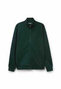 Chaqueta verde oscuro con cremallera y cuello alto, hecha de tela suave. Presenta mangas largas y bolsillos laterales. Diseño simple y estilizado.